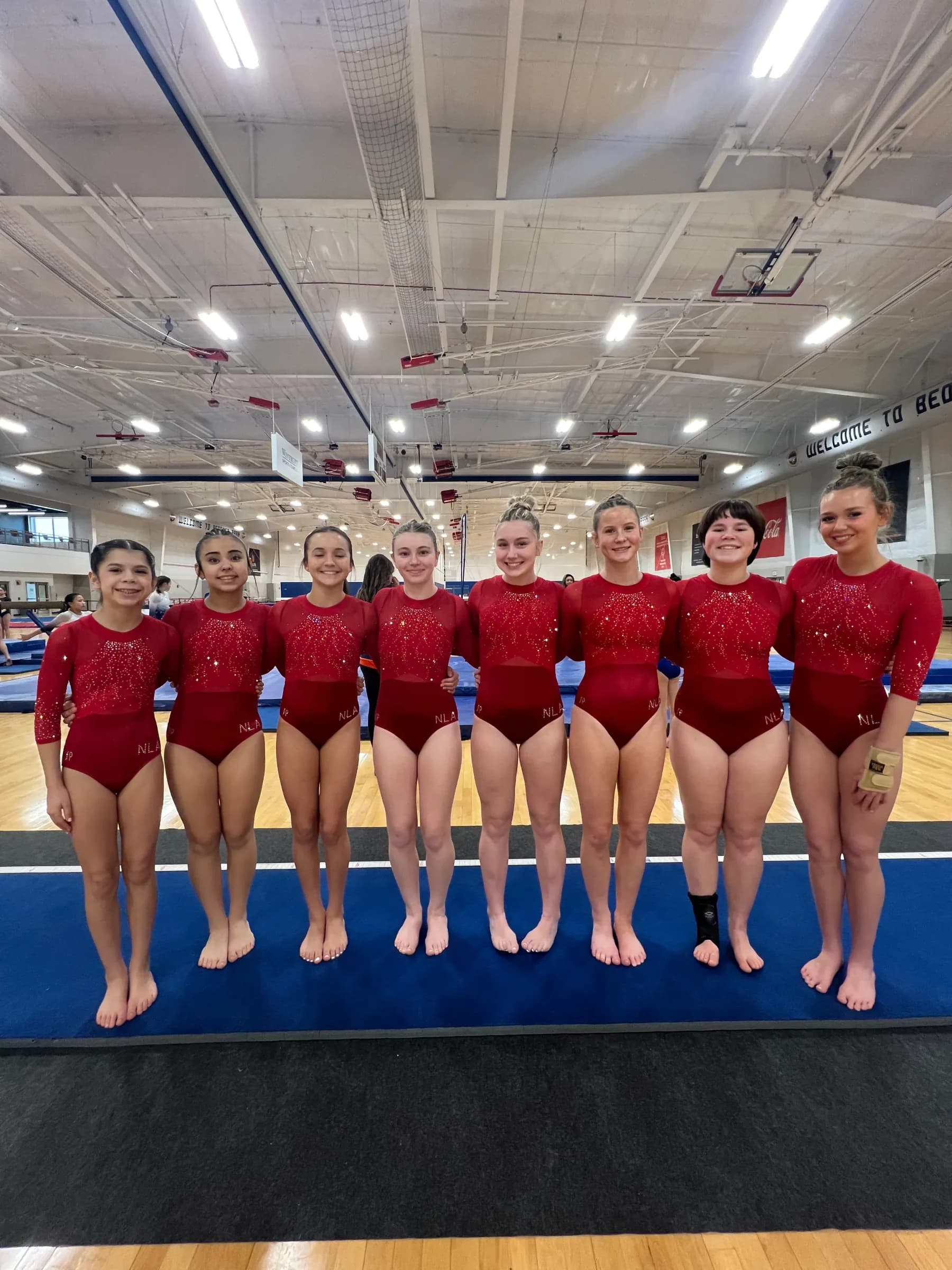 Next Level gymnastics team together on the competition floor